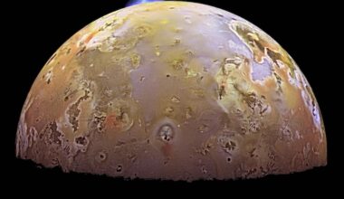 Planet-like body with mottled reddish-yellow surface and many spots. A small bluish plume shape is at the top.