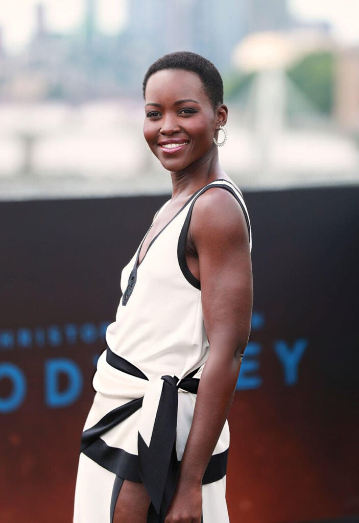 Lupita Nyong'o wears a black-and-white Chanel Resort 2027 look with cap-toe pumps at The Odyssey London photocall.