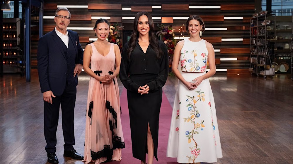 meghan markle wearing black dress with masterchef judges Jean-Christophe Novelli, Poh Ling Yeow and Sofia Levin.