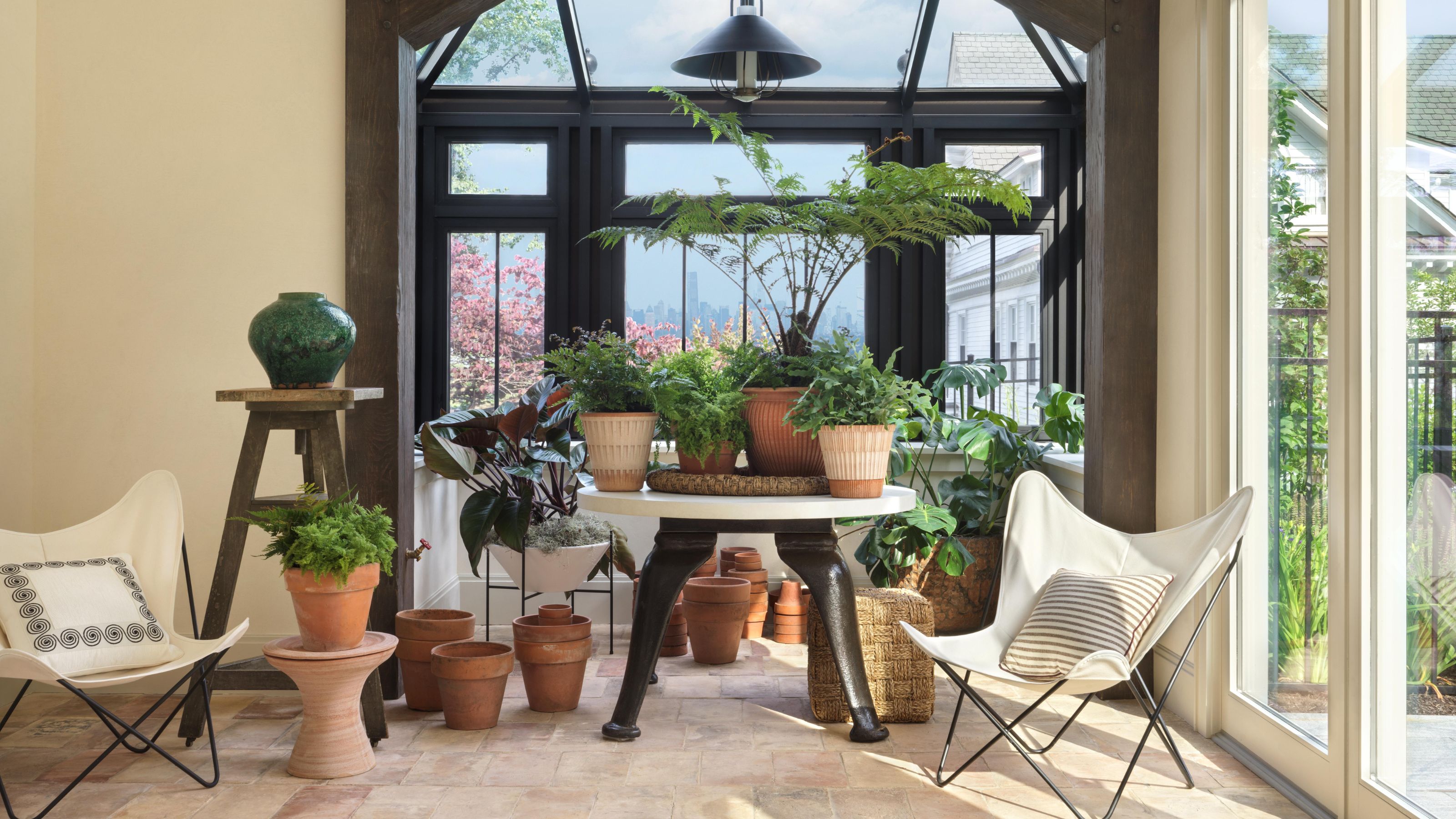 an indoor greenhouse in an 1887 carriage house with reclaimed terracotta tiled floor and plenty of indoor plants