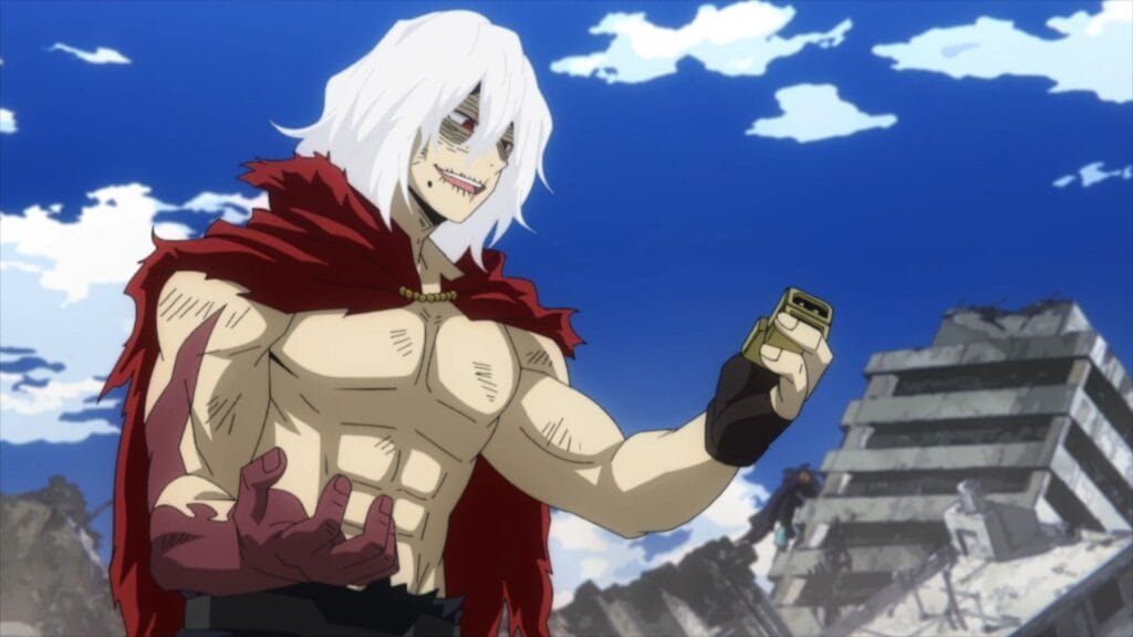 Still from My Hero Academia that depicts tomura Shigaraki, a white-haired, shirtless man wearing a cape and fingerless gloves. His right hand is red and discolored, and his face has an old, weathered appearance.