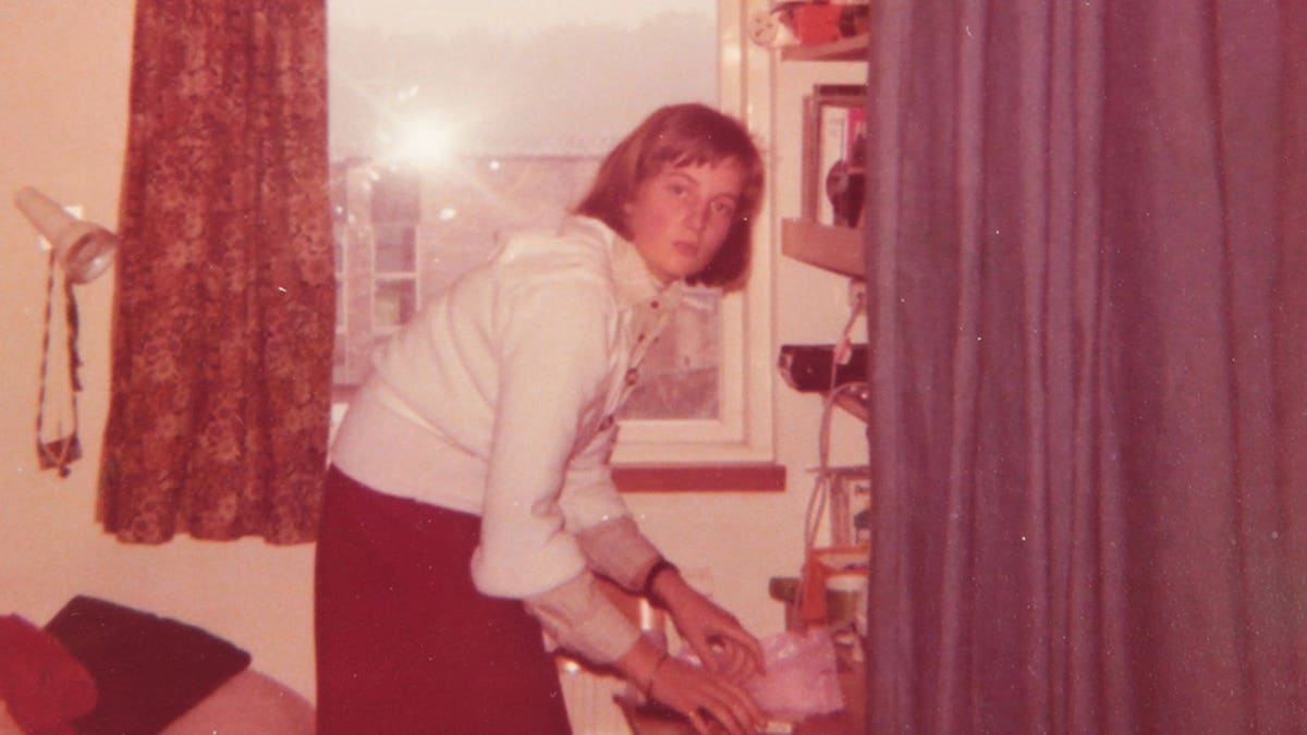 An old photo of a young Princess Diana tidying up.