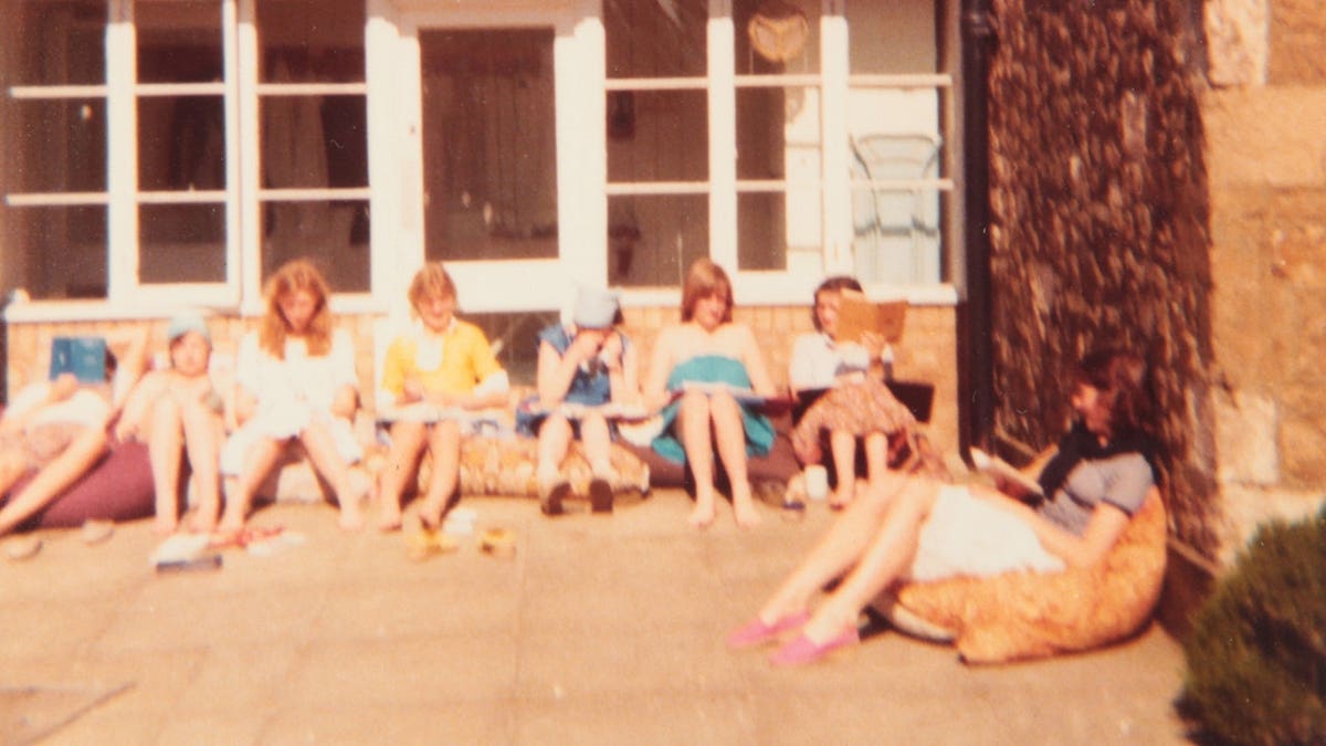 Princess Diana and her friends sitting outside their boarding school in England.