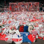 FILE - Liverpool soccer fans arrive at Anfield Stadium to pay their respects as flower tributes cover the 'Kop' end of the field, in Liverpool, on April 17, 1989, following April 15, when fans surged forward during the FA Cup semi-final between Liverpool and Nottingham Forest at Hillsborough Stadium in Sheffield, when the crash barriers gave way, killing 96 Liverpool fans and injuring over 200 others. A British judge has brought an end to a trial of two former police officers and an ex-lawyer on charges of perverting the course of justice in connection with the 1989 Hillsborough soccer disaster that saw 96 Liverpool fans die. Judge William Davis told jurors Wednesday, May 26, 2021 at a court in Salford, northwest England, that there was no case they could properly consider for the defendants. Donald Denton, an 83-year-old retired chief superintendent at West Yorkshire Police, former detective chief inspector Alan Foster, 74, and former solicitor Peter Metcalf, 71, had been charged of amending police statements following the disaster in an attempt to minimize blame on the force.( AP Photo, File)