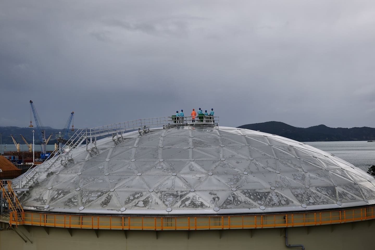 Officials, including PM Christopher Luxon, are dwarfed by the size of the new fuel storage tanks at Channel Infrastructure. Photo / Dean Purcell
