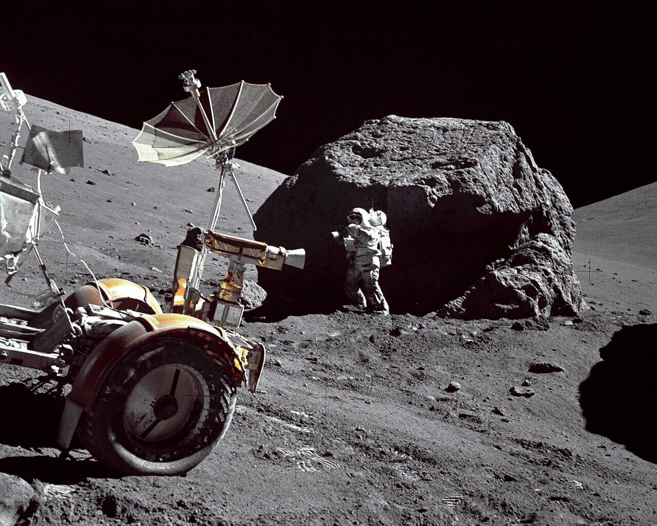Geologist-Astronaut Harrison H. Schmitt is photographed standing next to a huge, split boulder at Station 6 on the sloping base of North Massif during the third Apollo 17 extravehicular activity (EVA-3) at the Taurus-Littrow landing site. Credit: NASA