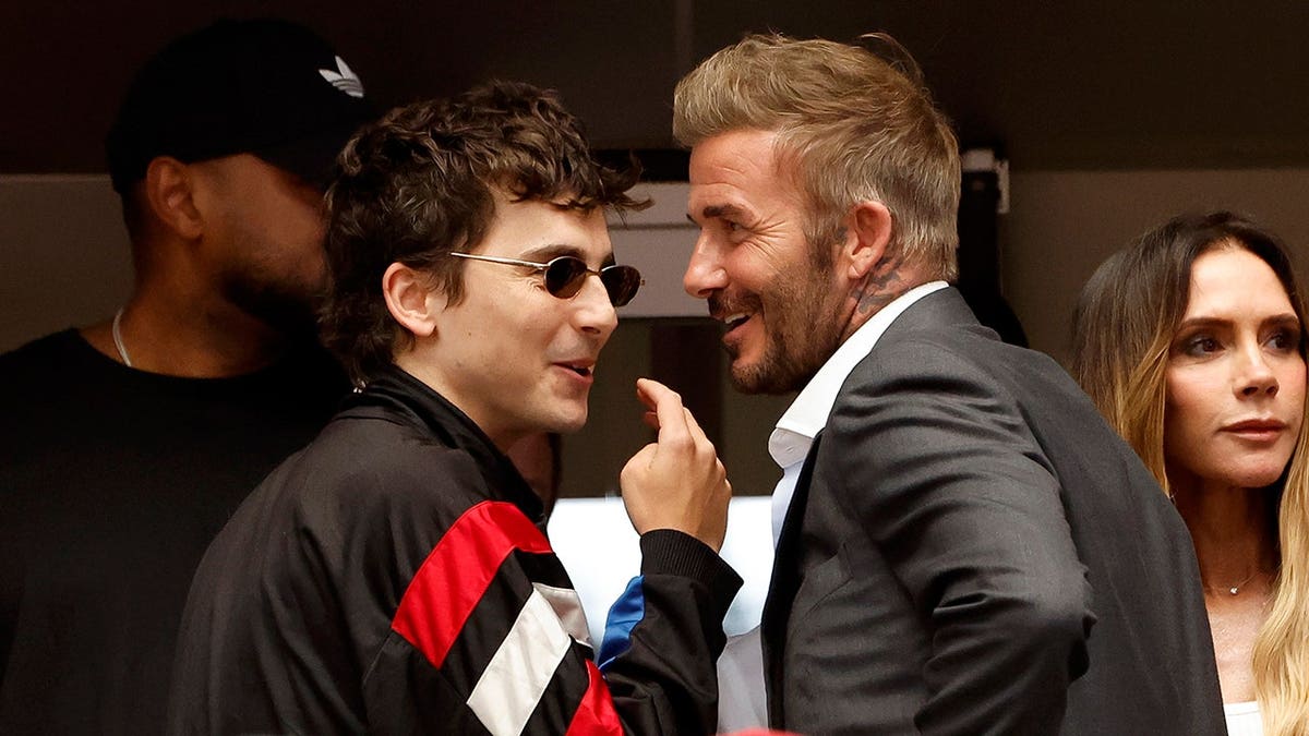 Timothee Chalamet chats with David Beckham and Victoria Beckham in a stadium.