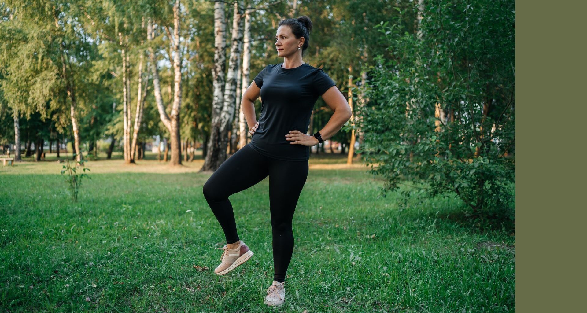 Woman doing standing ab exercises in park wearing activewear