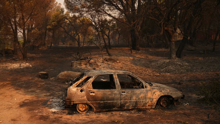 A car burned by a wildfire sits in Piedralaves, Ávila province, Spain, as the fire continues to spread.