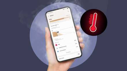 A hand holding a phone showing battery settings, with a red heat icon in the background