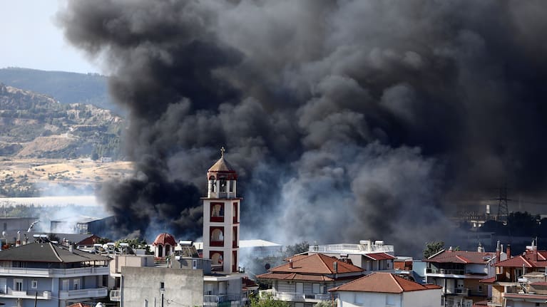 A helicopter drops water over a wildfire on the outskirts of the northern city of Thessaloniki, Greece, Sunday, July 5, 2026.
