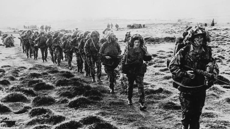A line of British soldiers in camouflage advancing across East Falkland island for the final attack on Port Stanley during the Falklands War, June 1982.