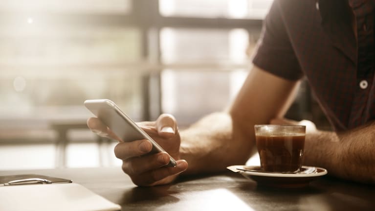 A man using his cell phone at a cafe (file image).