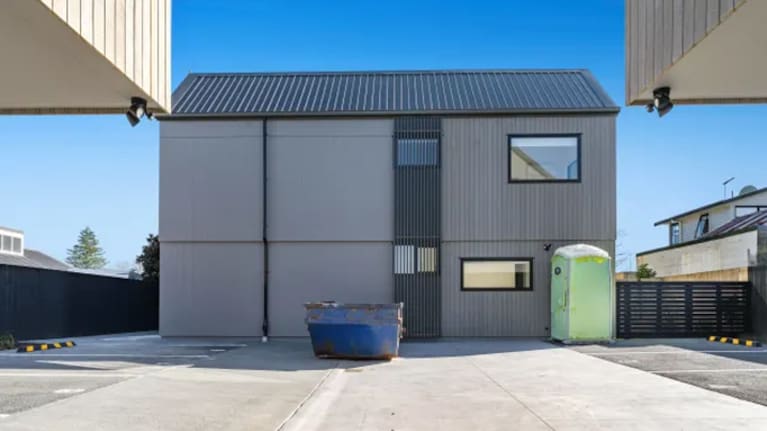A real estate property before it is AI-enhanced to remove the skip bin and portaloo. (Source: Supplied / BuildVision)