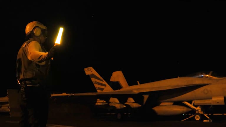 A screenshot from a video shared by the US military showing a jet taking off from an aircraft carrier.