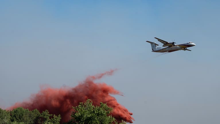 A water bomber drops water while fighting wildfires In Ares, western France, Friday July 24, 2026.