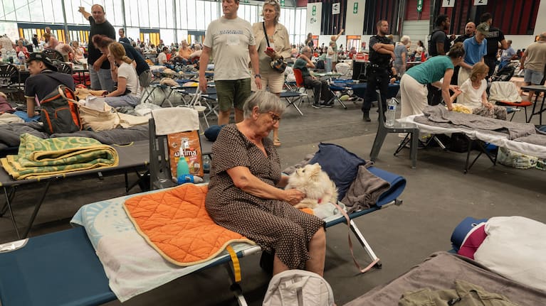 A woman caresses her pet dog at an emergency shelter set up in the Bordeaux Exhibition Centre in Bordeaux, France.