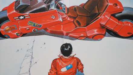 A drawn image from Akira (the manga) of a young man (Kaneda) standing in front of a large futuristic motorcycle. He’s wearing a motorcycle jacket with a pill on the back. 