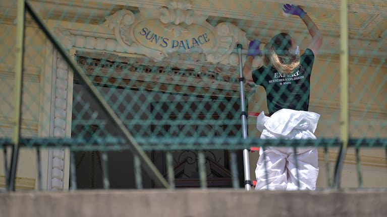 An investigator examines the scene at the residential building where an explosive device seriously injured three people a day before, in Monaco, Tuesday, June 30, 2026.