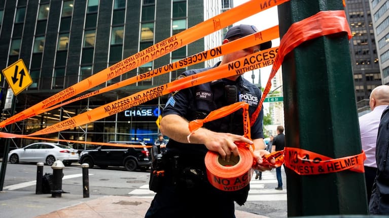 An NYPD officer puts up caution tape near East 41st St after buildings in the area were evacuated in New York.