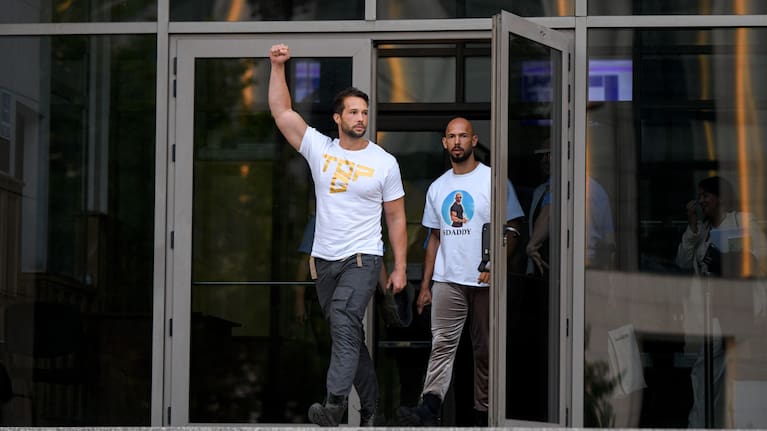 Andrew Tate, right, and his brother Tristan, left, exit the Bucharest Tribunal after being placed under house arrest, in Bucharest, Romania.
