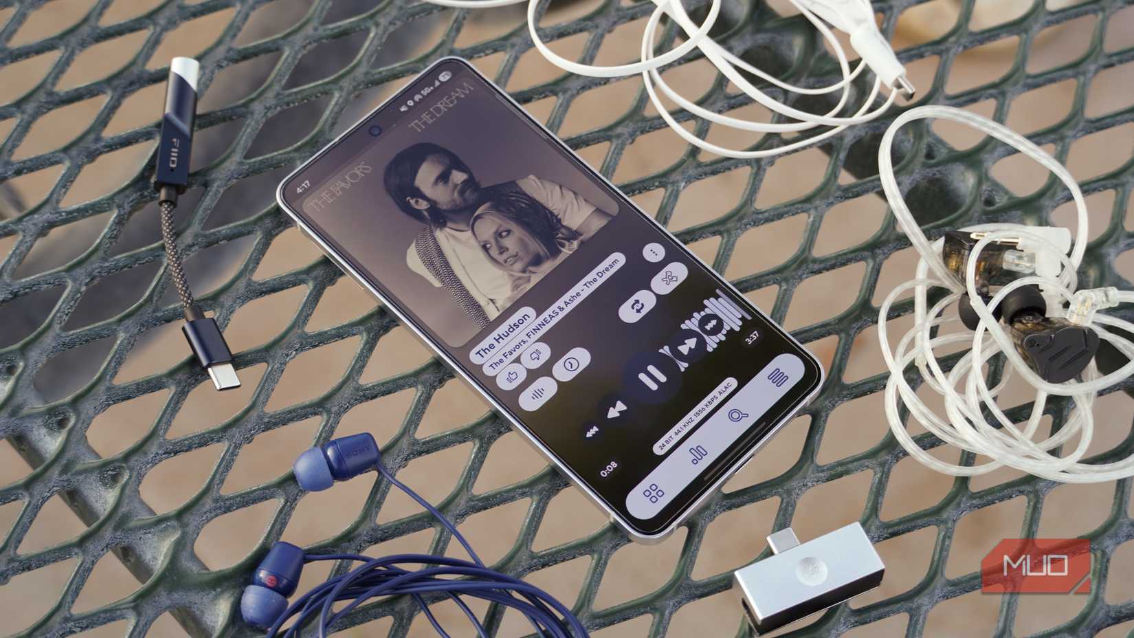 An Android phone on a table with lossless audio gear spread around it. 