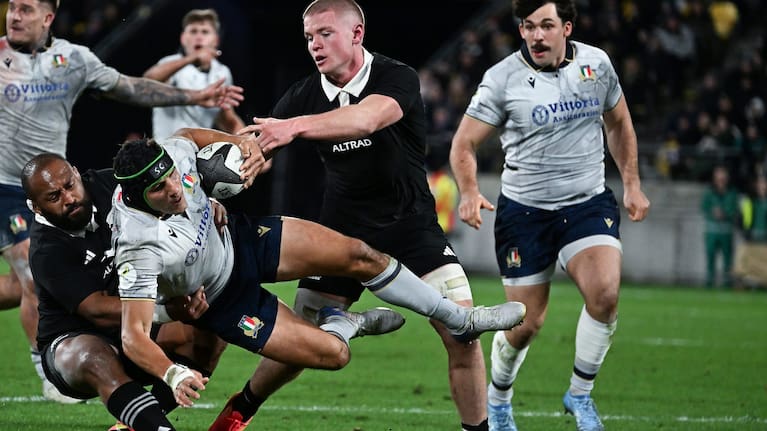 Anton Segner helps George Bower make a tackle against Italy.