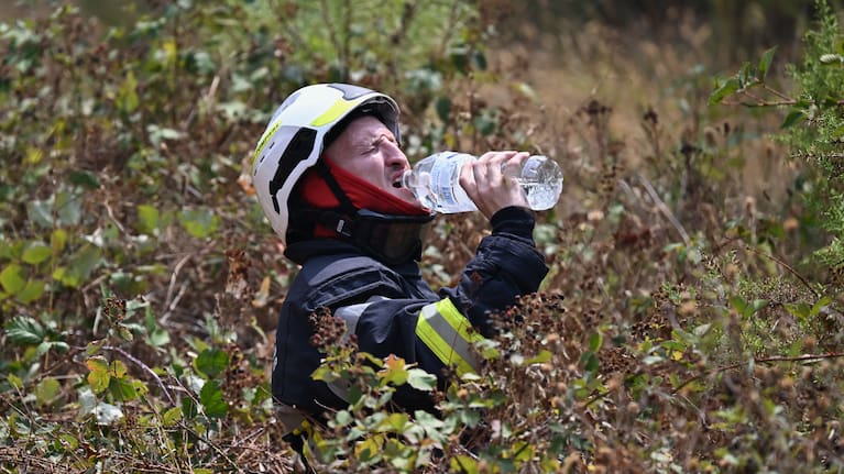A firefighter takes a drink of water while battling a wildfire near Le Temple, outside, Bordeaux
