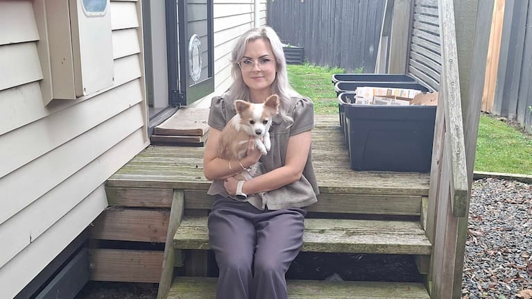 Ashlei Sherwood sits with her surviving dog Kylo near the spot where she found her beloved 11-year-old chihuahua cross Charlie dead after being mauled by the neighbour’s dog.