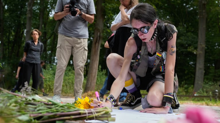 Ashley Jump lays flowers near the scene where a car rammed into a crowd near the Pride March in Berlin, Germany, Sunday, July 26, 2026