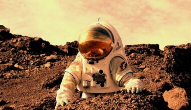 Microbes on Mars: Astronaut in bulky white suit standing near a big red boulder in reddish terrain with dusty yellow sky above.