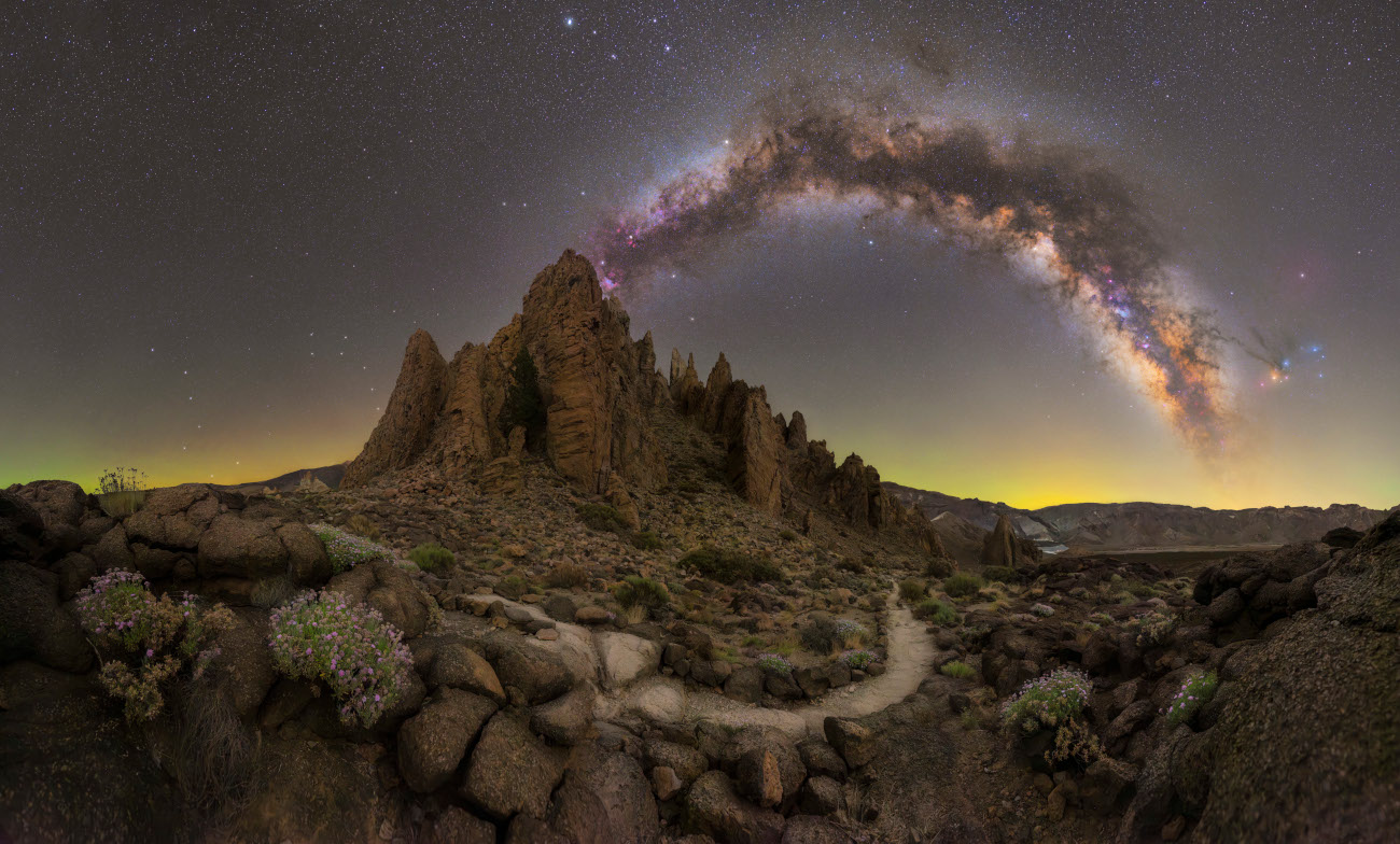 Path Towards the Stars © Matteo Strassera (Italy) This panorama was taken in Tenerife, in the rocky and volcanic landscape of the Teide Plateau. Here, bushes and flowers find their way through the hardened lava. Matteo Strassera composed the image to show the path winding around the peaks and pointing towards the galaxy. Strassera had less than an hour before the arc of the Milky Way rose too high in the sky to capture the panorama, so he rushed to capture all the detail that a 35-mm focal length can offer. Taken with a Canon EOS R5 camera, Benro Polaris tripod head, Foreground: 14 mm f/4, ISO 4320, 8 x 121-second exposures; Sky: 35 mm f/1.6, ISO 400, 32 x 60-second exposures Location: Santa Cruz de Tenerife, Tenerife, Canary Islands, Spain, 25 June 2025