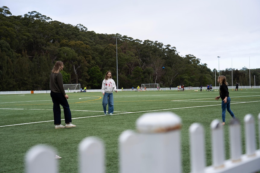 Woman and two girls playing at park