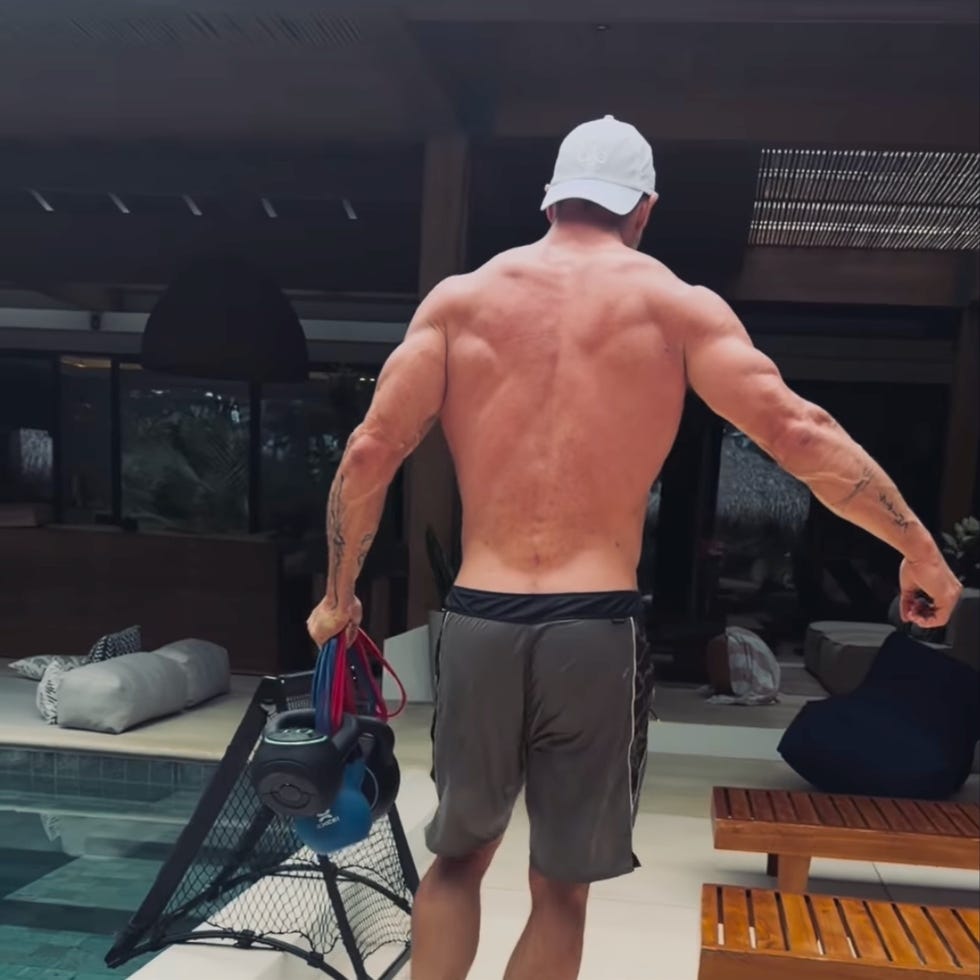 shirtless man with a backpack and equipment near a pool railing. shirtless man with a backpack and equipment near a pool railing.