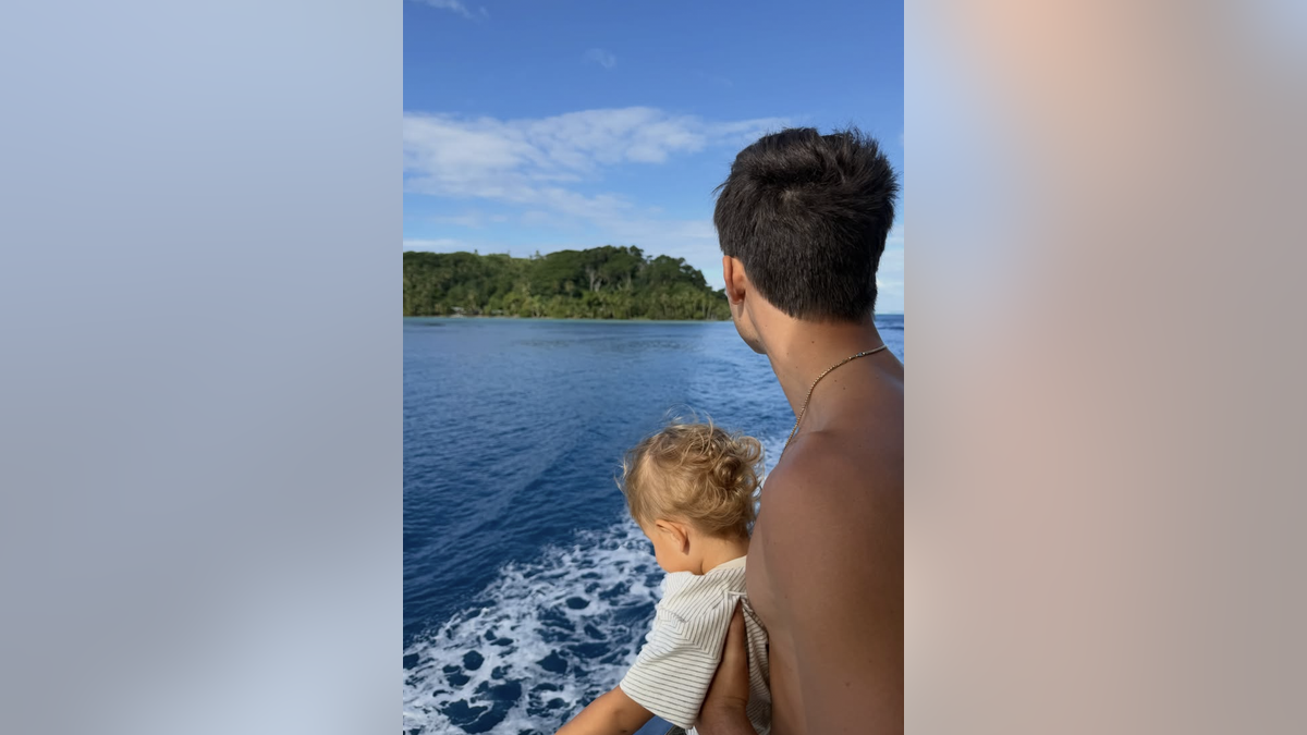 Benjamin holds baby brother on boat