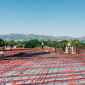 August 2023, A look at the roof slab captures ironworkers precisely mapping a dense structural matrix of reinforcing rebar intertwined with the bright red protective sheaths of the post-tensioned cabling network.. Image © Aleksey Kondratyev “Building a Swiss Watch Out of Concrete”: Clark Construction on LACMA’s David Geffen Galleries - Image 26 of 27