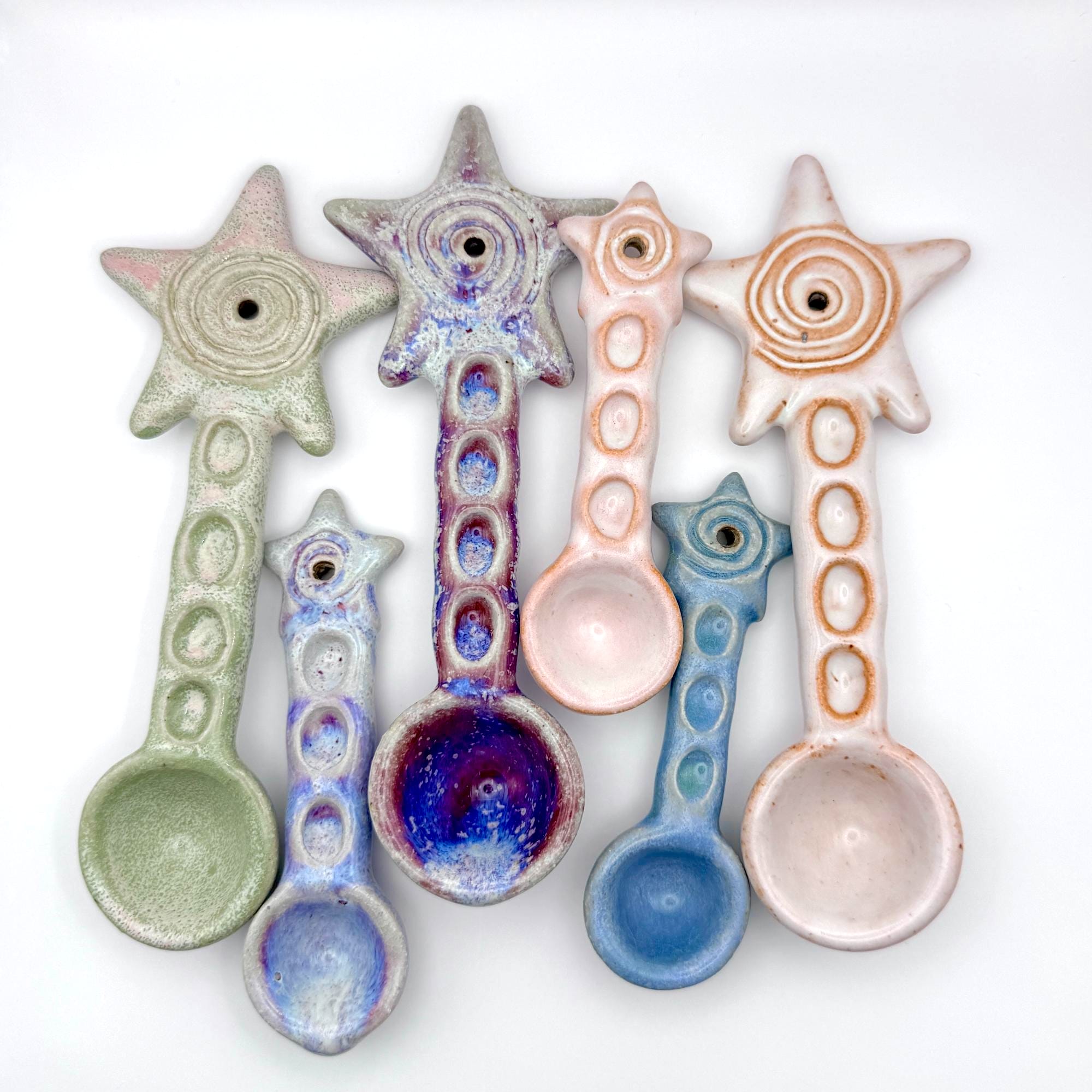 a collection of ceramic spoons with stars on the end