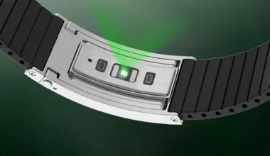 Silver smartwatch with black segmented band showing green light sensor on the underside.
