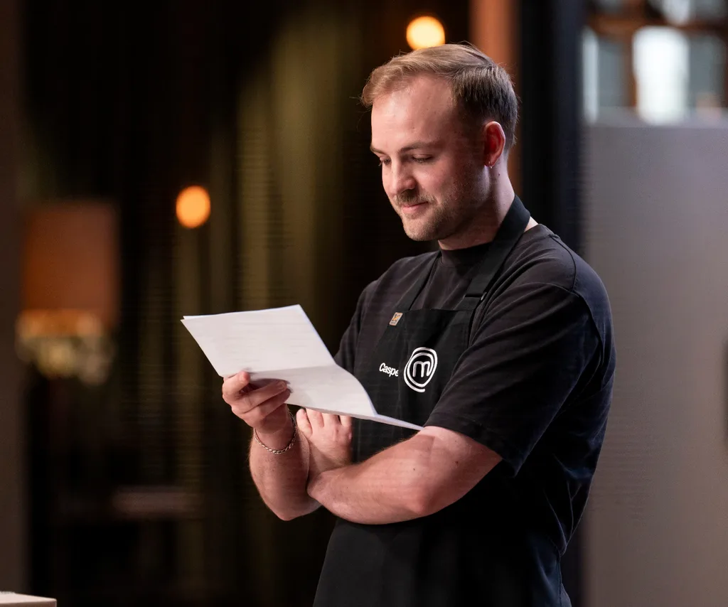 Casper Kenworthy reading an emotional letter from his parents in the MasterChef Australia kitchen.