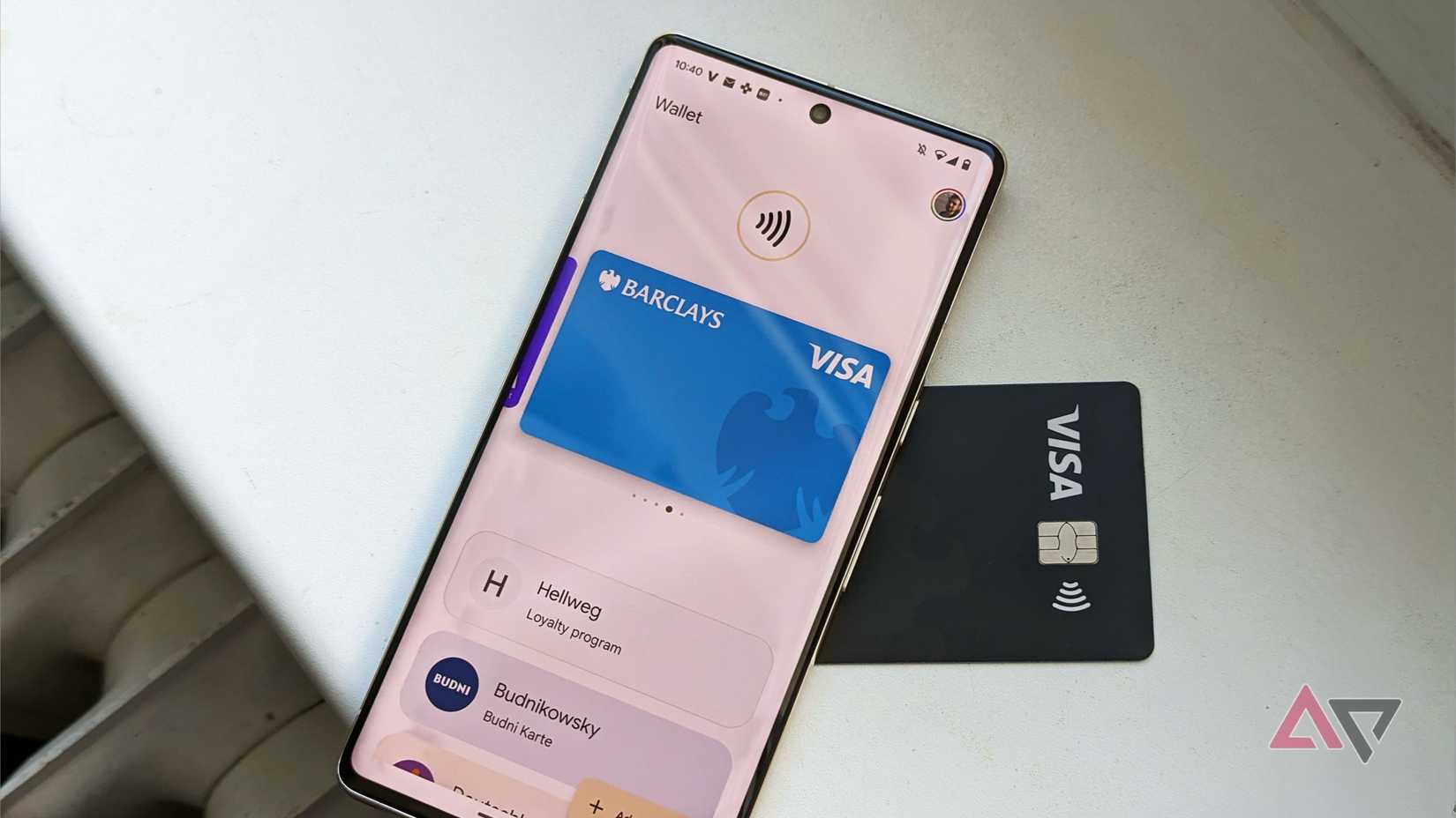 Google Wallet app on an Android phone next to a credit card