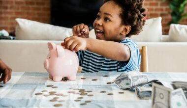 Photo of a young child putting money into a piggybank.