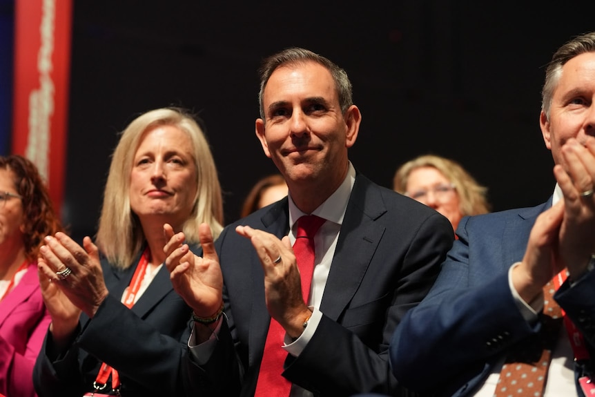 Smiling politicians, clapping at a conference