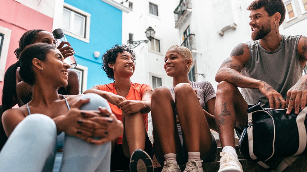 A group of friends having a chat together after a workout. - PintoArt // Shutterstock