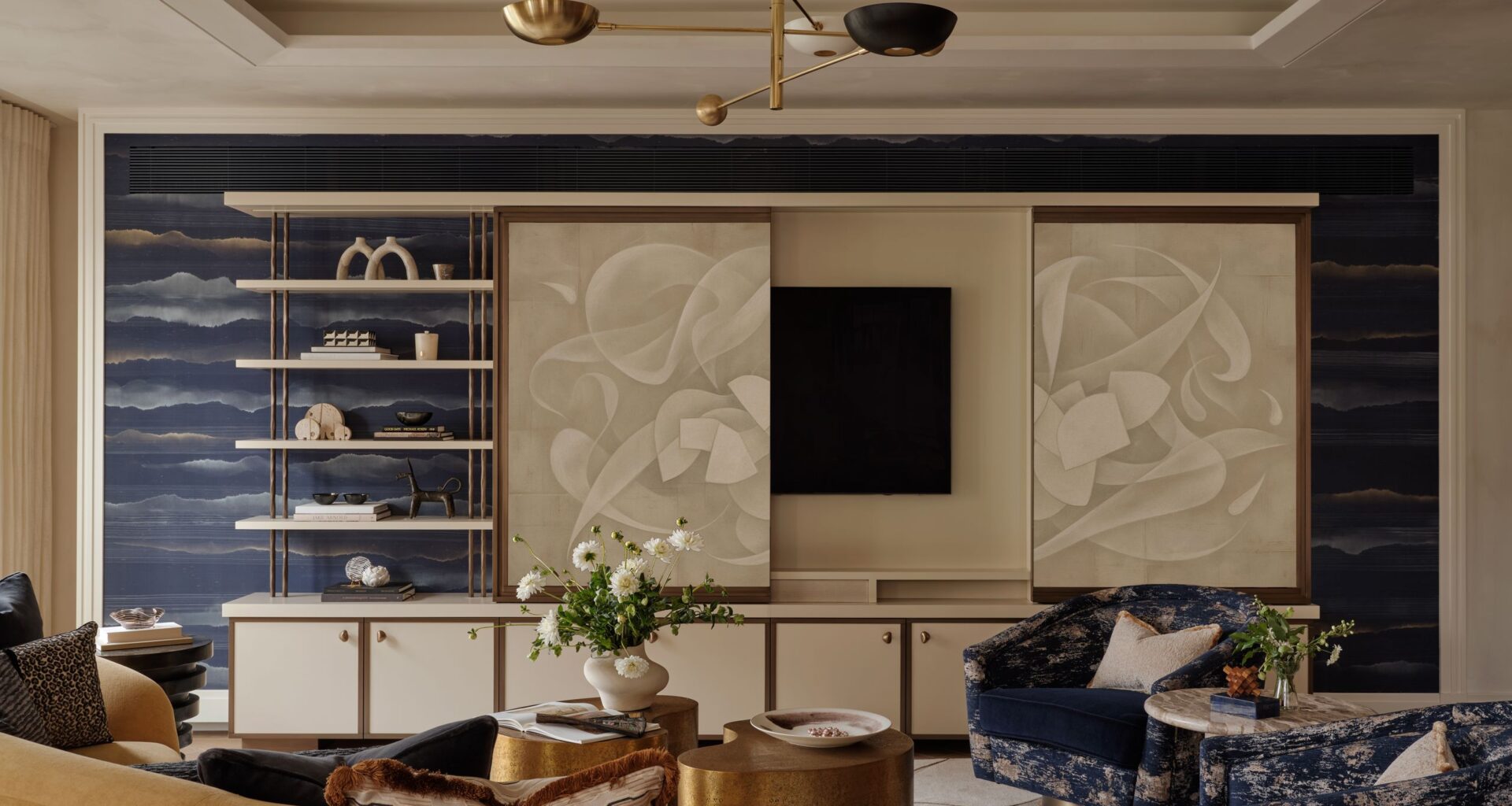 living room with tv hidden behind screen panels fronted by art