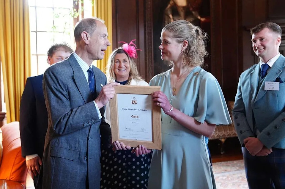 A photo of Lady Louise and Prince Edward holding a certificate