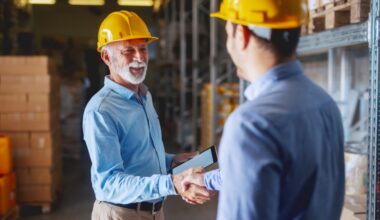 two men wearing yellow helmets and hand shaking