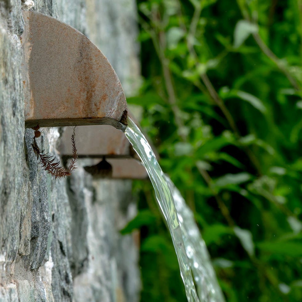 wall fountain gushes in a rural park