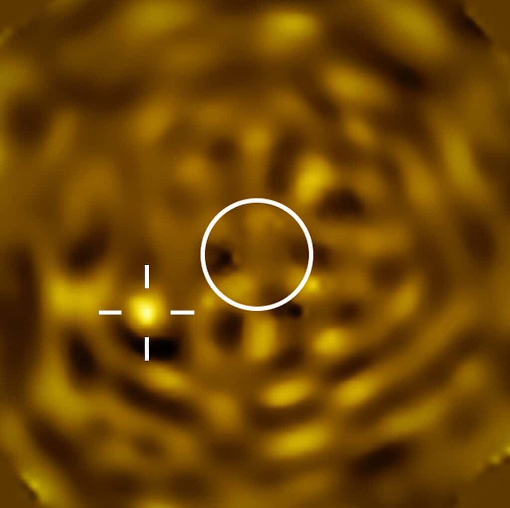Astronomy image of betelgeuse b beside betelgeuse. Bright blur against a blurry gold background