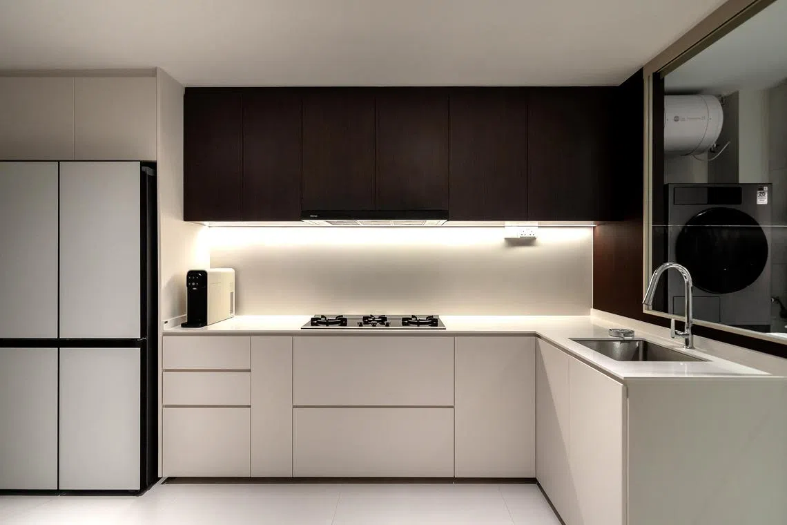 The all-white kitchen creates an impression of neatness and organisation.