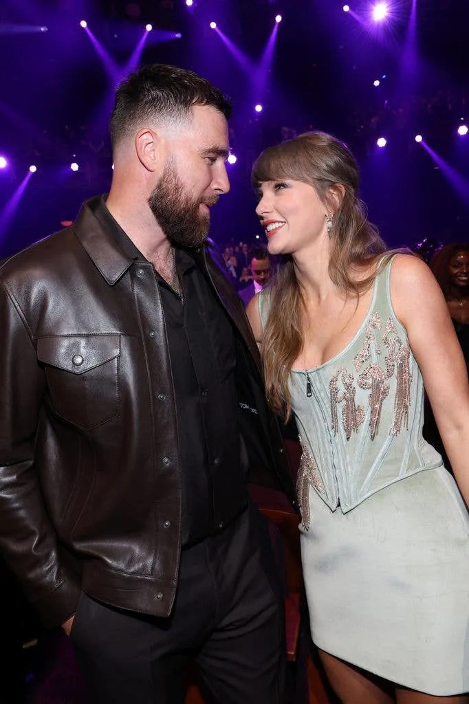 photo of travis kelce and taylor swift smiling at each other